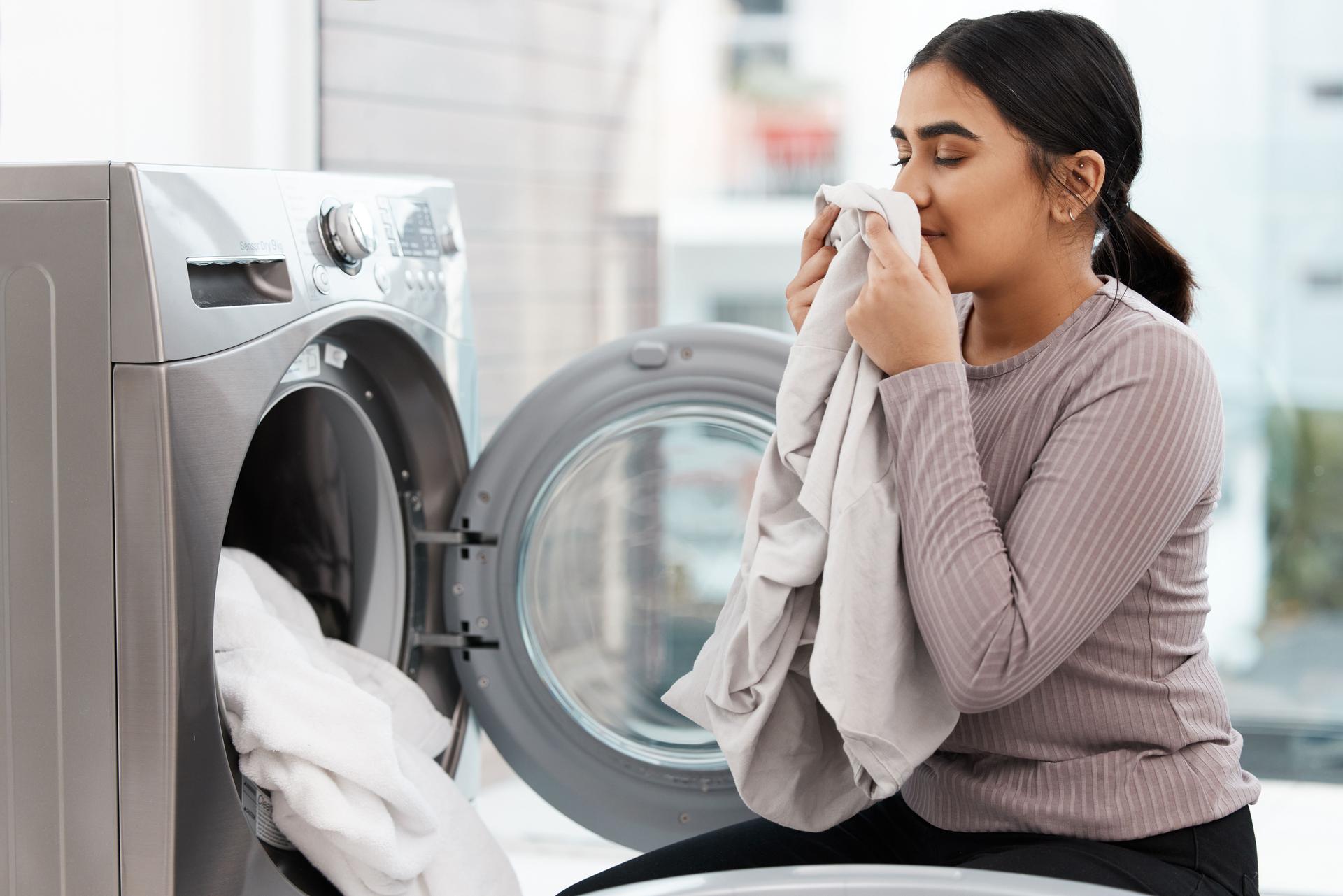 Shot of a beautiful young woman doing the laundry at home