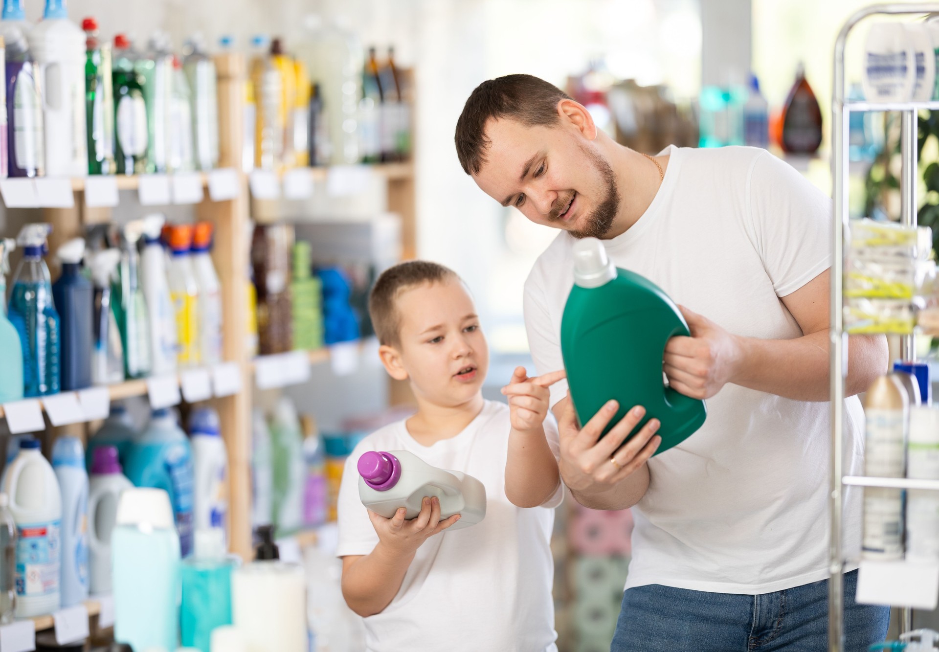 Schoolboy son and dad are choosing big capacity liquid detergent in store